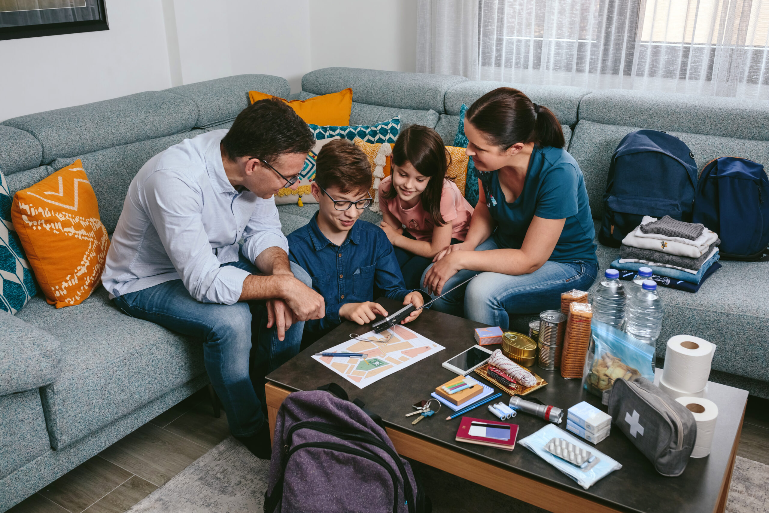 Parents explaining to their children how to use the radio while preparing emergency backpacks Step 1: Meet with Your Family