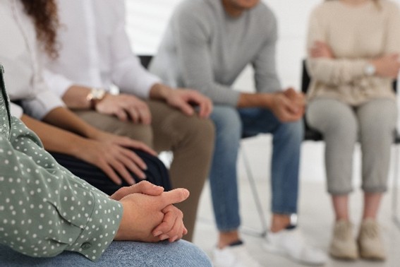 group of people sitting in chairs in a circle
