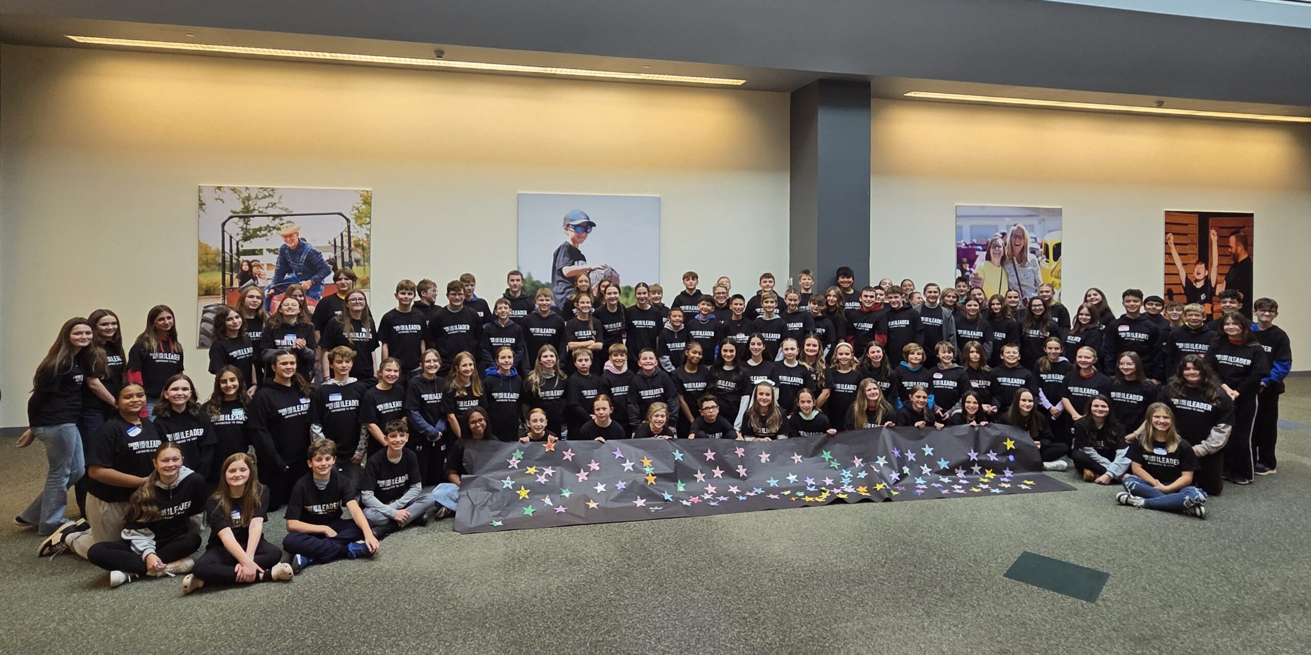 Picture of middle school students in a large group with a banner