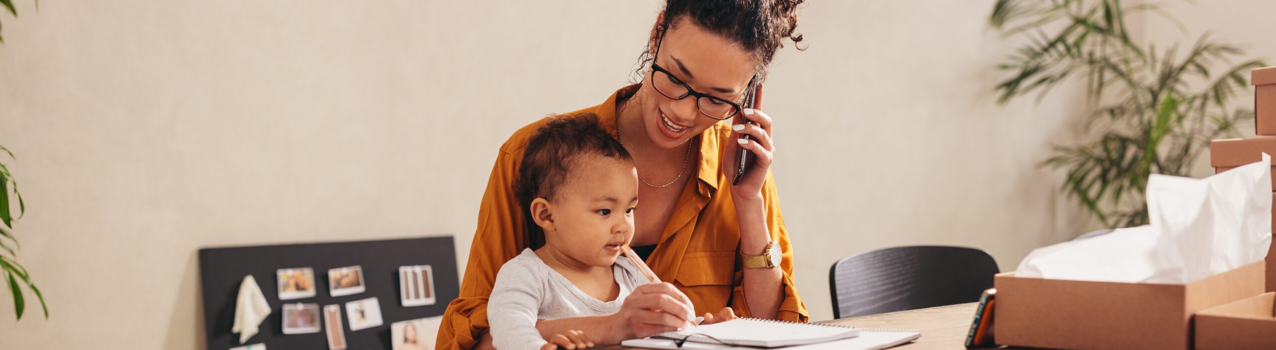 Mother talking on smart phone at home office