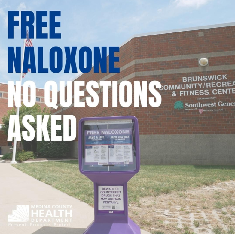 Purple kiosk that houses naloxone with text Free Naloxone No Questions Asked