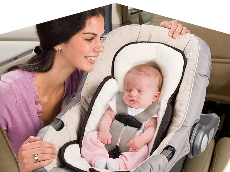 Image of a mom and her baby strapped into a car seat.